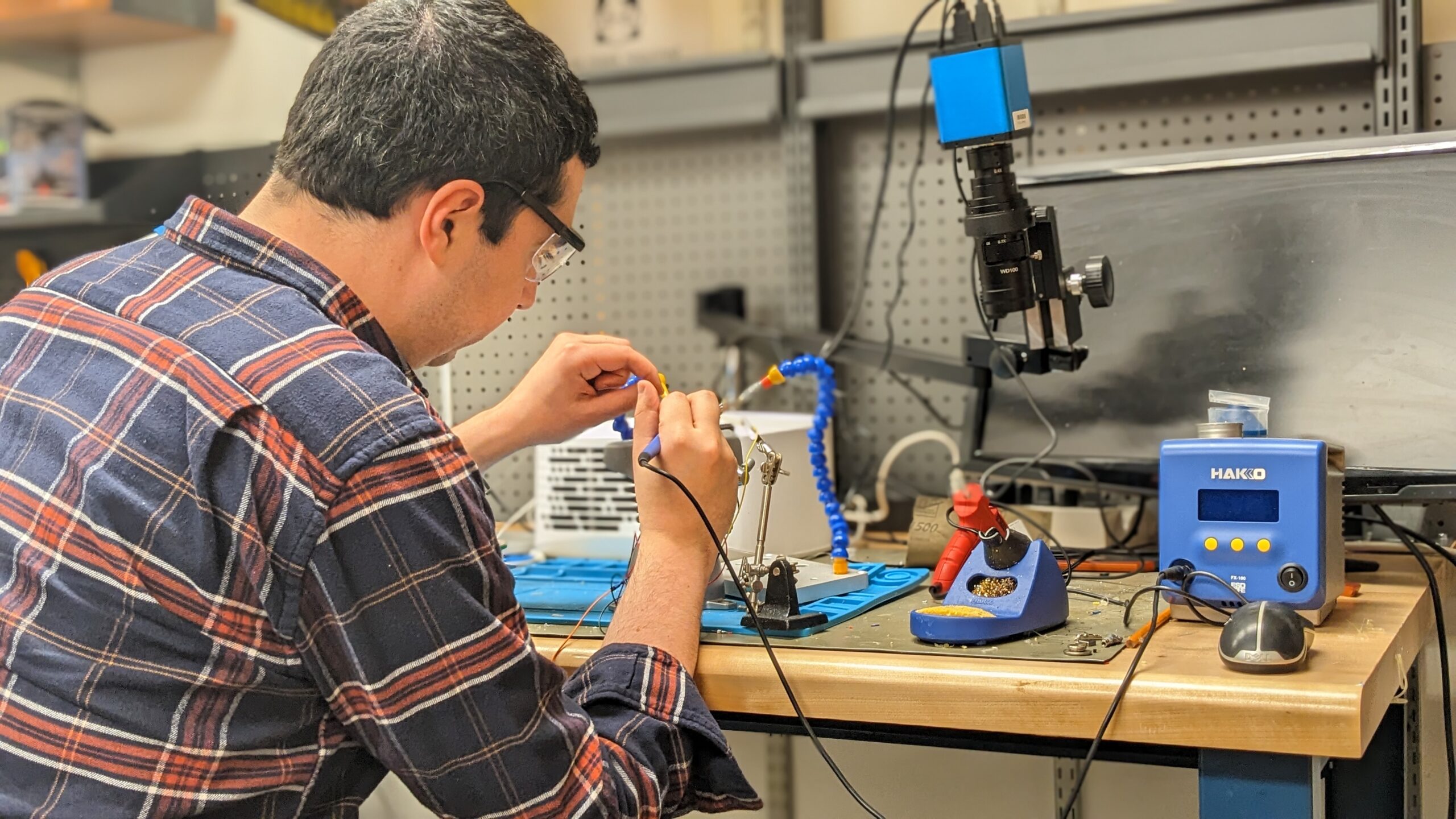 Alex Mariakakis altering a pair of noise-cancelling earbuds to allow data collection of blood pressure monitoring.